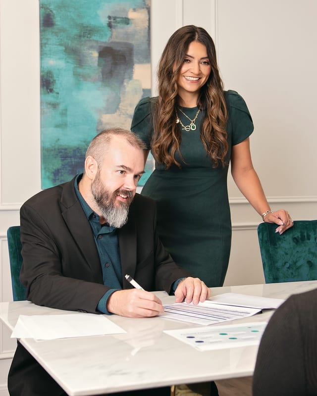 Julie and Cody Wall going through plan options with a client at their office.